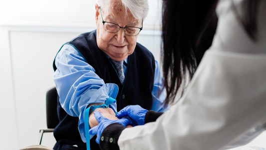 Nurse drawing blood from an elderly man