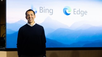a man standing in front of the Bing and Edge logos