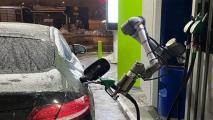 a robot arm pumping gas into a car