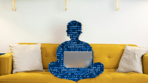 a silhouette of a person on a couch using a laptop