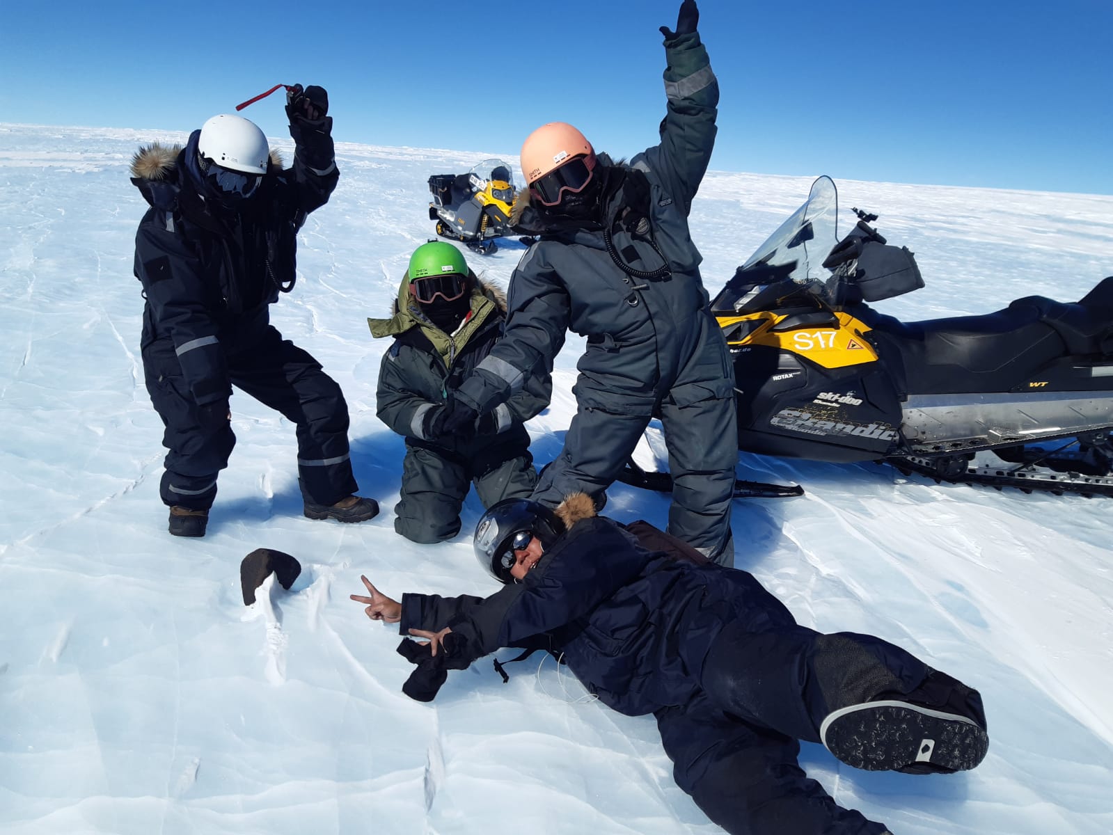 Cuatro personas en la nieve con un meteorito en el suelo