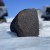 a large black rock in the snow