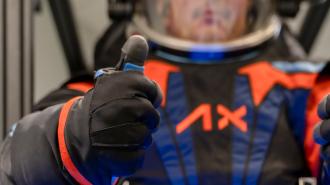 a close up of a person in a spacesuit giving a thumbs up