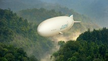 massive airship flying above a forested valley