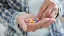 a close up of multiple types of pills in a hand