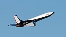 a spaceplane flying across a blue sky