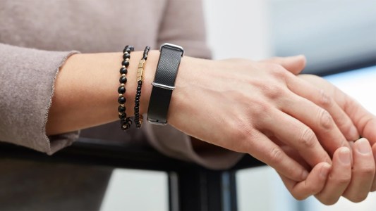 a closeup of a woman's hand wearing a black wristband and bracelets
