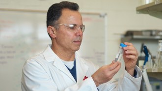 a scientist looking at a test tube of water