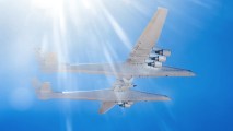 a massive airplane mid-flight. a smaller hypersonic aircraft is attached to its underside