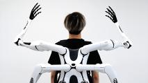 a person wearing four robotic arms on their back