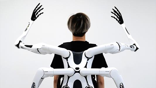 a person wearing four robotic arms on their back