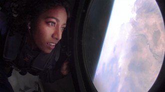a person looking at Earth out the window of a spacecraft