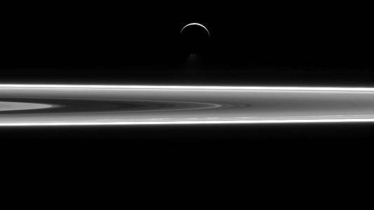 a photo of Enceladus and Saturn's rings