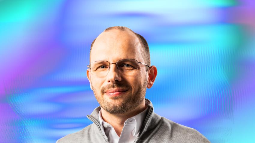 a headshot of Github CEO Thomas Dohmke on a colorful background