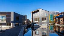 House in Amsterdam on a canal with a reflection in the water.