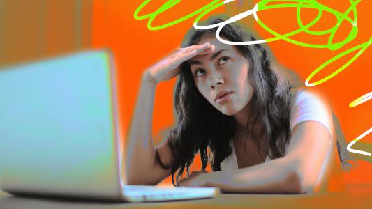 A woman using gall's law with a laptop on an orange background.