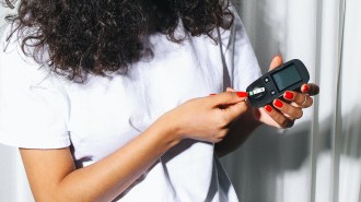 A woman holding a cell phone while receiving islet transplantation for brittle diabetes.