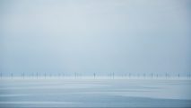 a large body of water with wind turbines on it.