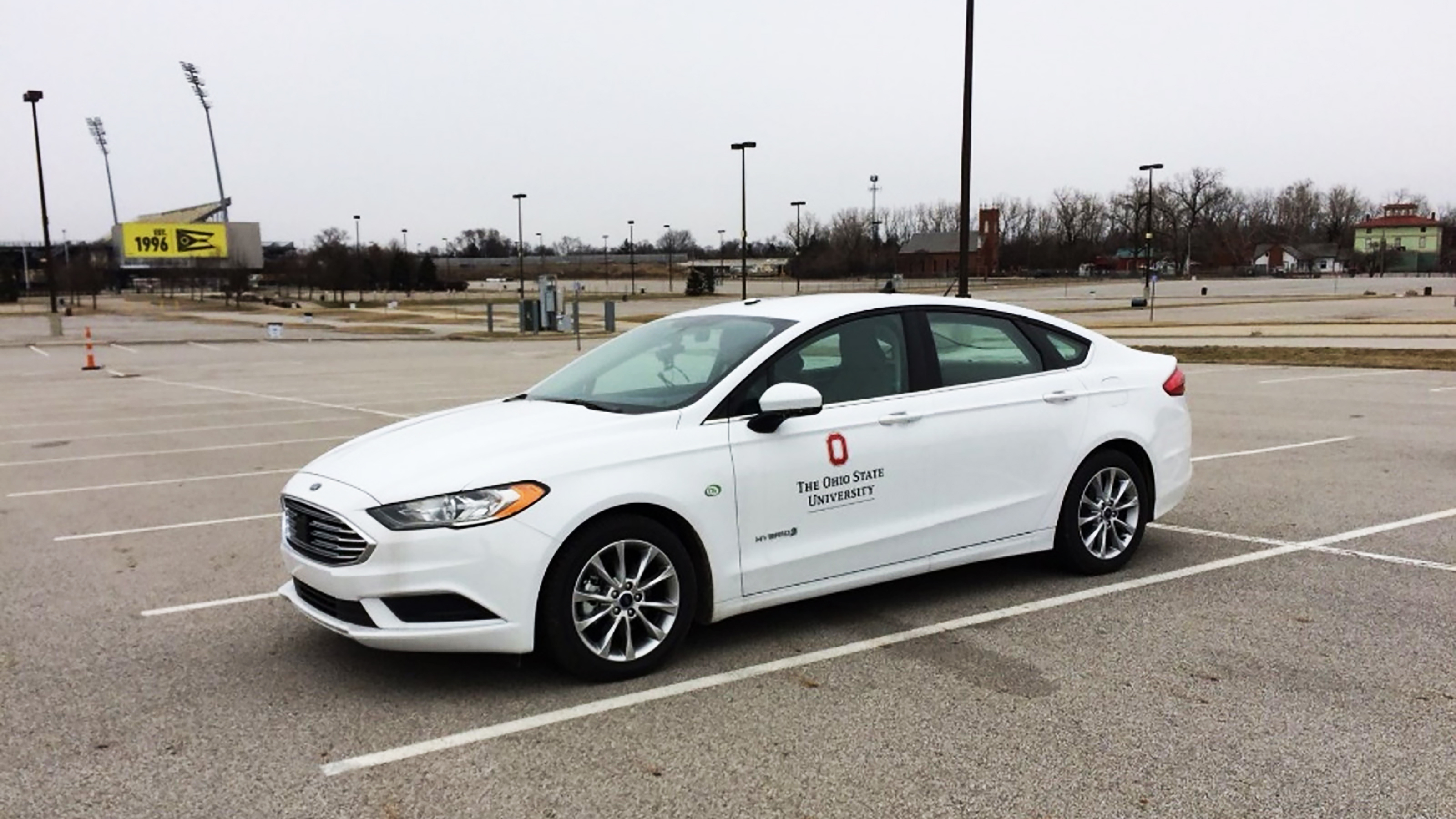 a white self-driving car parked in a parking lot.