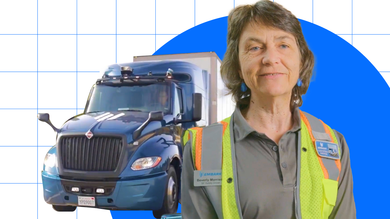 A woman is standing next to a semi truck.