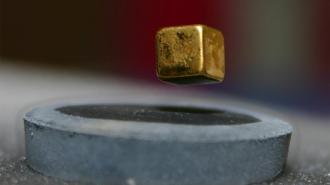 a cube of metal floating above a magnet