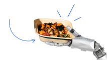 A robot hand is holding a container of food.