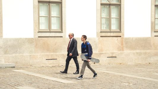 A man and a woman walking down a cobblestone street.