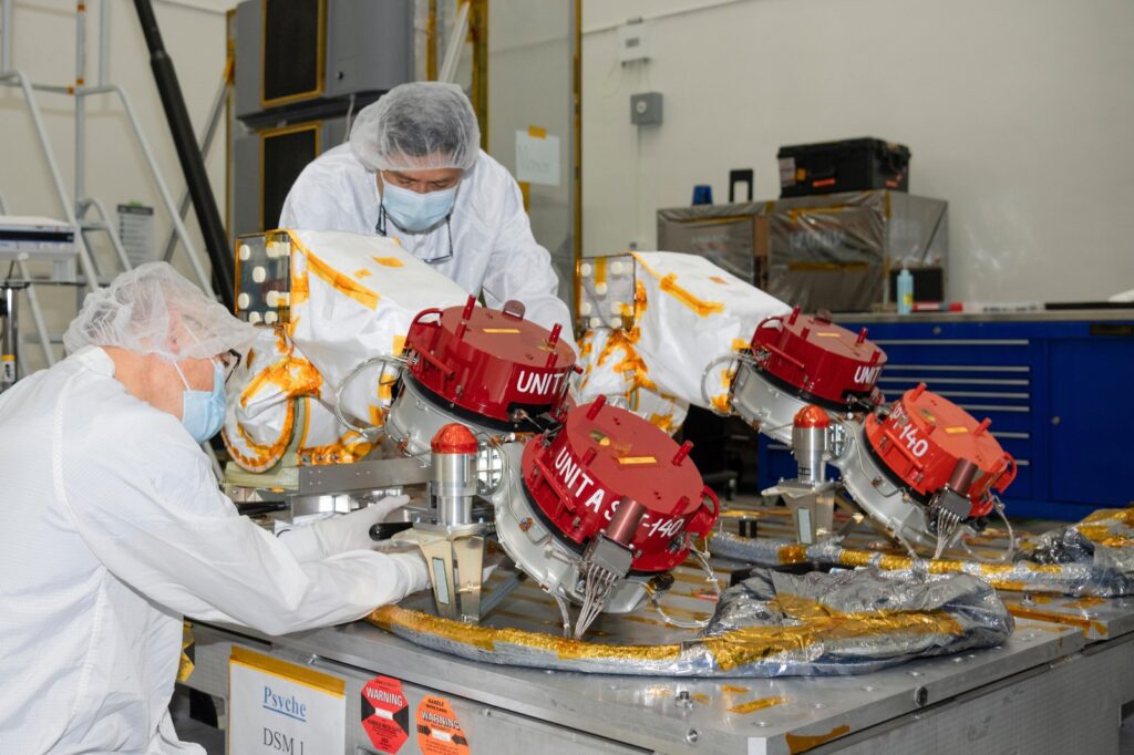 Two engineers working in a lab over a piece of aerospace equipment