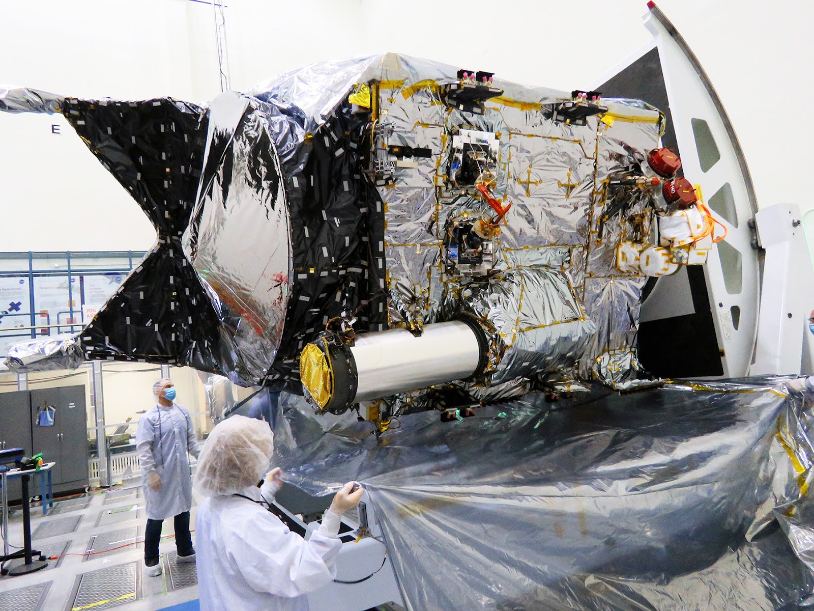 A group of people working on a spacecraft in a factory.