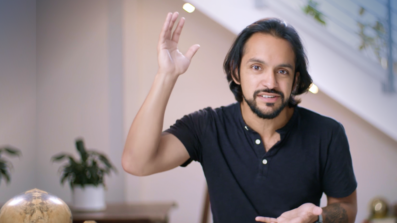 A man in a black shirt is waving his hand in the air.