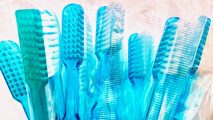 A bunch of blue toothbrushes in a plastic bag to combat tooth decay.