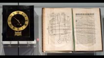 A book and a clock on display in a museum.