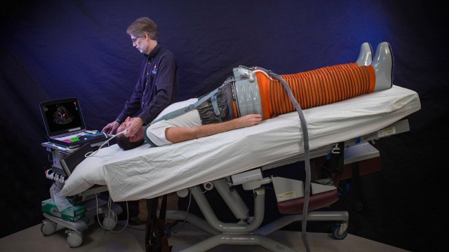A man experiencing space effects on the body while laying on a bed with a machine.