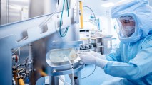 A person in a protective suit in a vaccine manufacturing facility