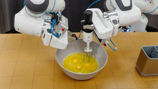 A robot is learning to mix eggs in a bowl.