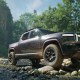 A pickup truck is parked in a rocky area.