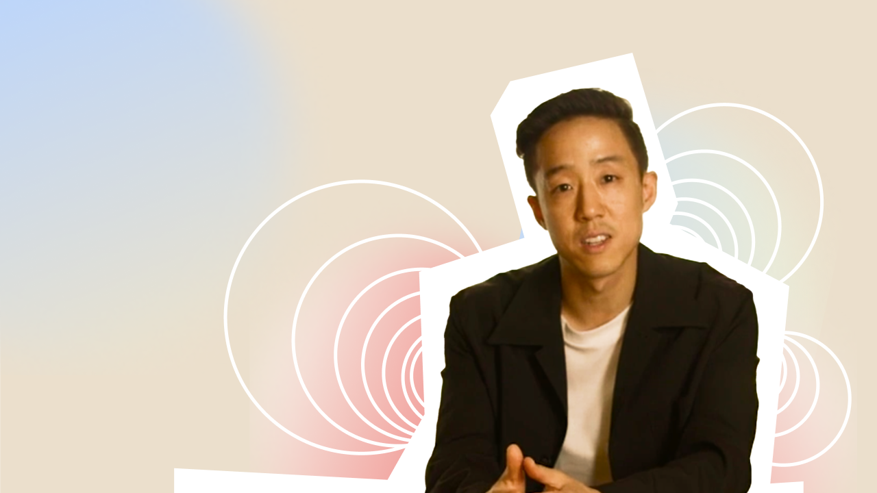 A man is sitting in front of a colorful background.