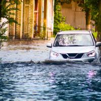 A car driving through a flooded street.