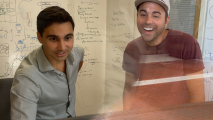 Two men smiling in front of a whiteboard.