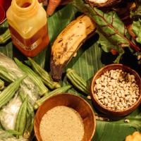 A table full of food on a banana leaf.