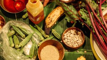 A table full of food on a banana leaf.