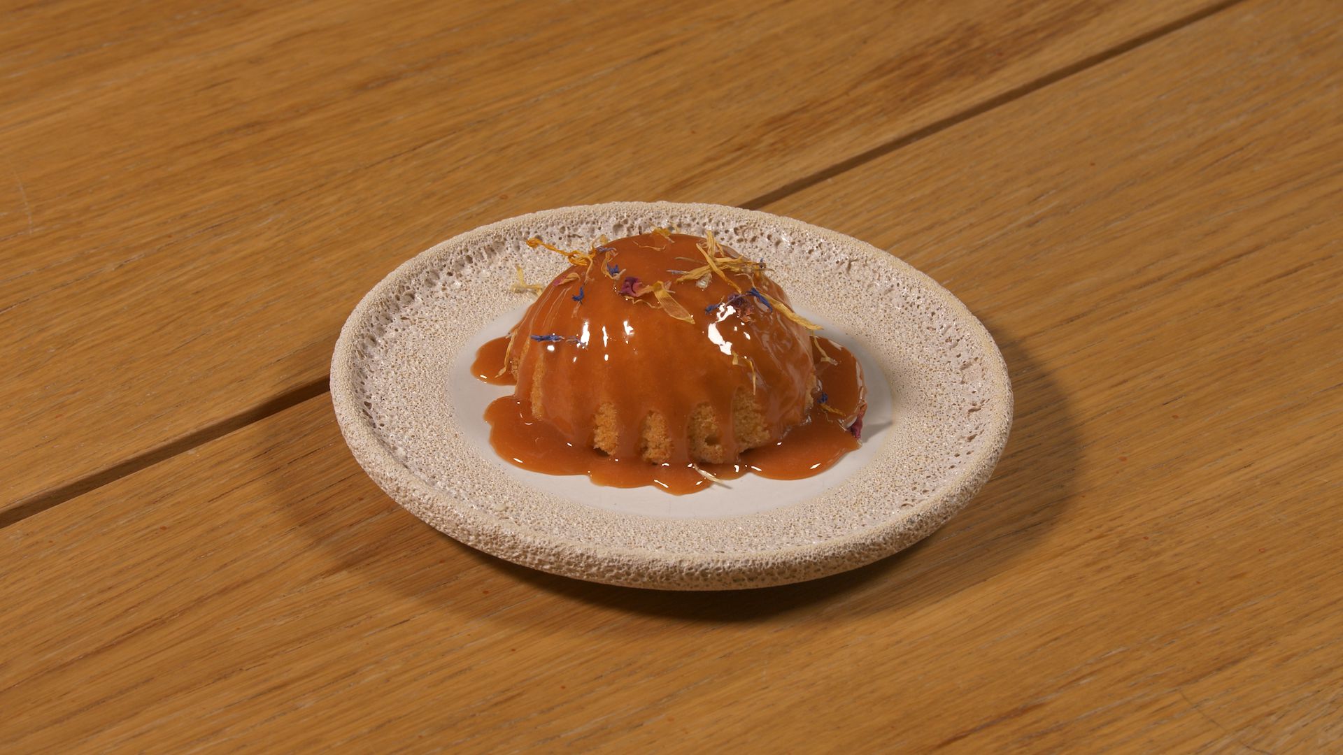 A dessert is sitting on a plate on a wooden table.