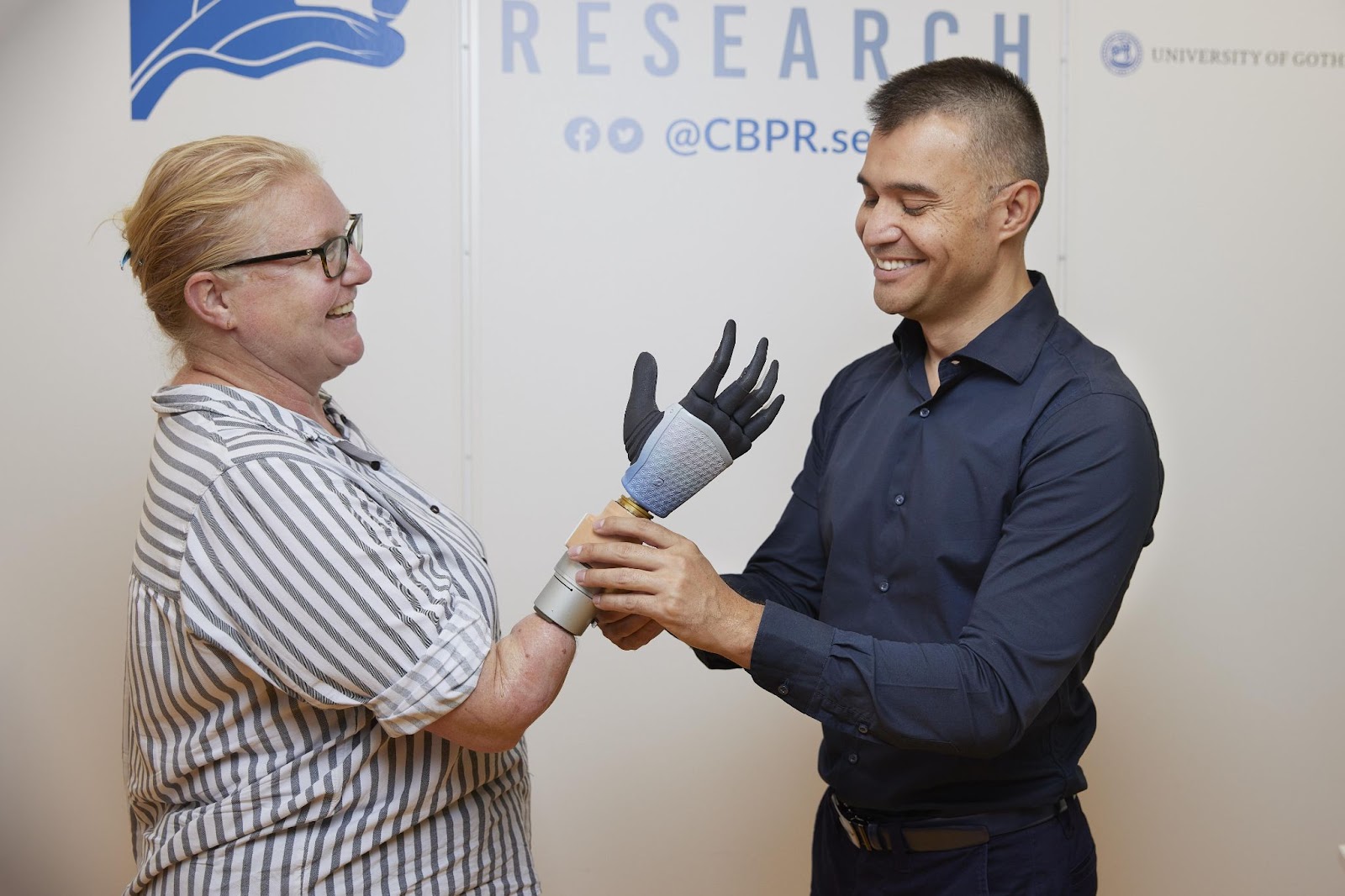 A woman with a bionic hand standing next to a man