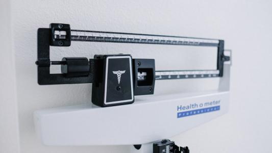 A medical scale hanging on a wall.