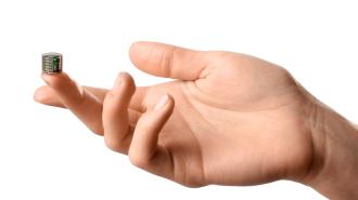 A person's hand delicately holding a small cube used for neurostimulation