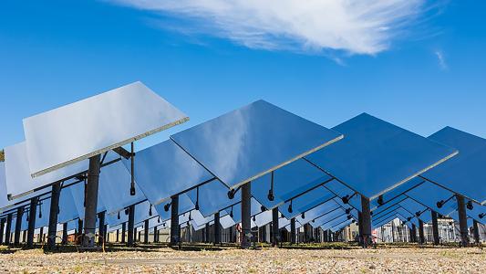 a field filled with large mirrors used for concentrated solar power