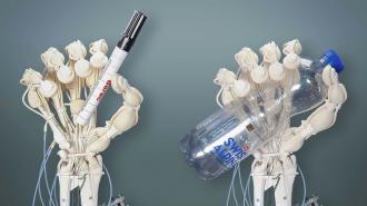 two robotic hands holding a marker and a water bottle