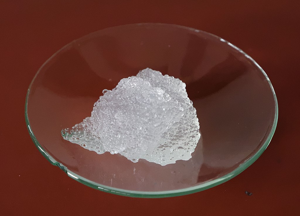 A piece of ice sitting in a glass bowl.