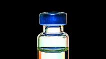 A glass vial with a blue lid