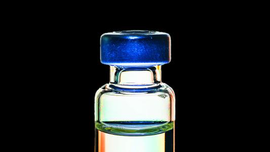 A glass vial with a blue lid